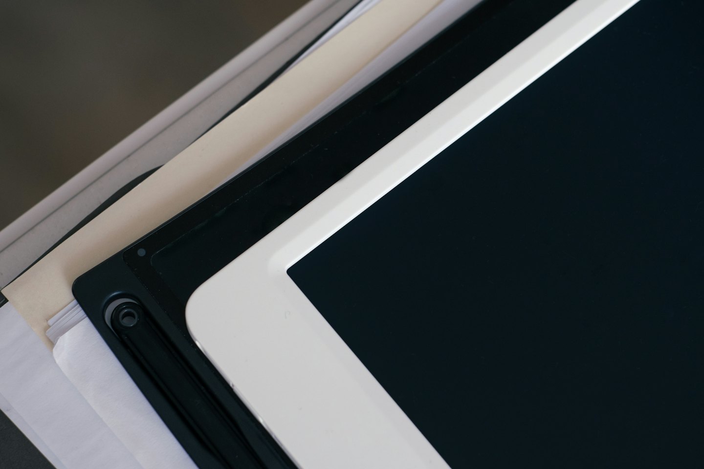 Tablet s prázdnou obrazovkou leží na kancelárskych dokumentoch.